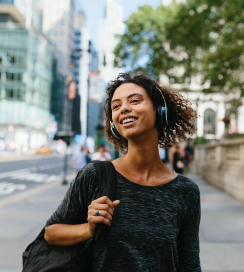 Young woman listening to headphones on the streets of NYC