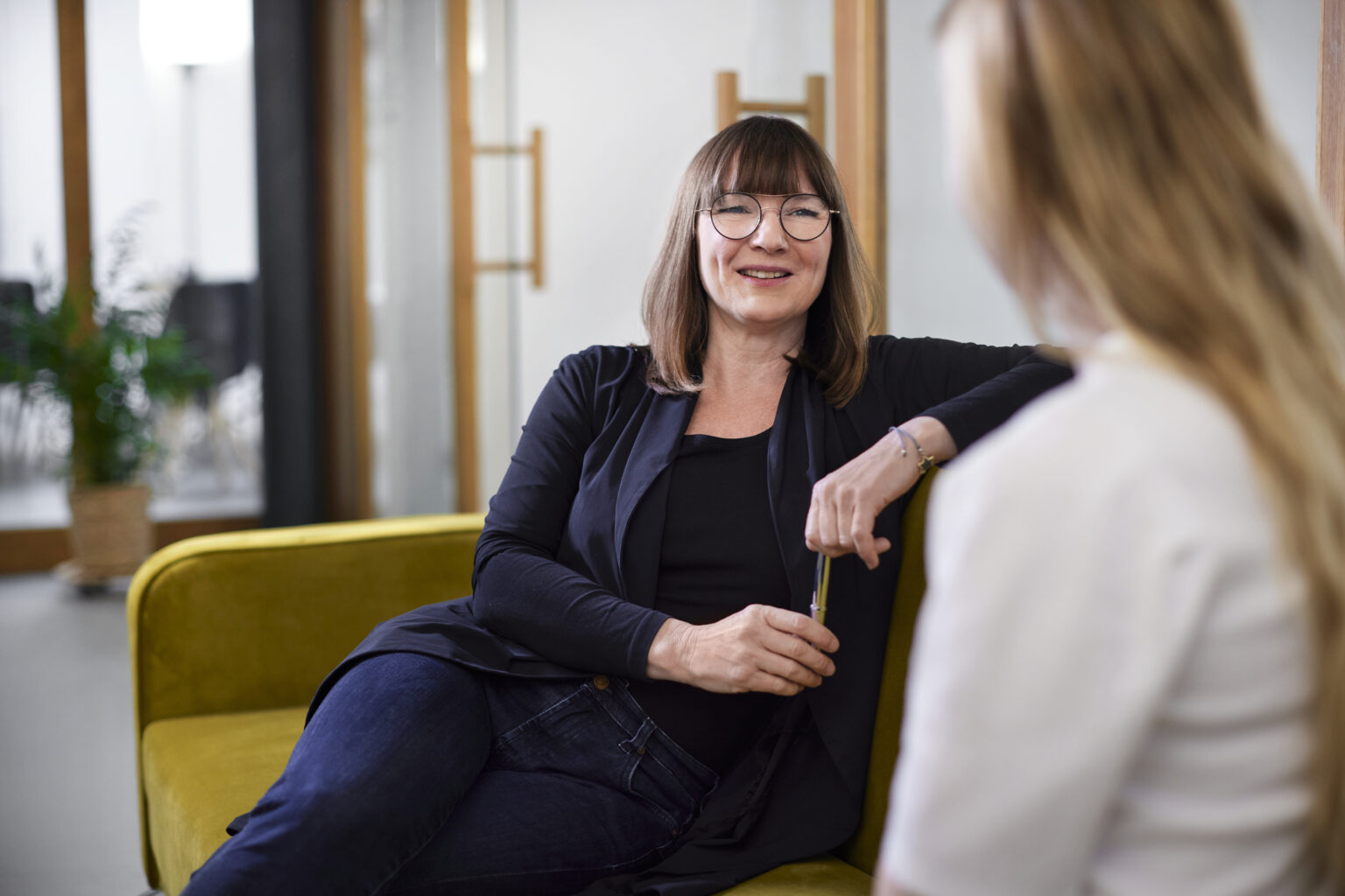 Two businesswomen talking on couch in office